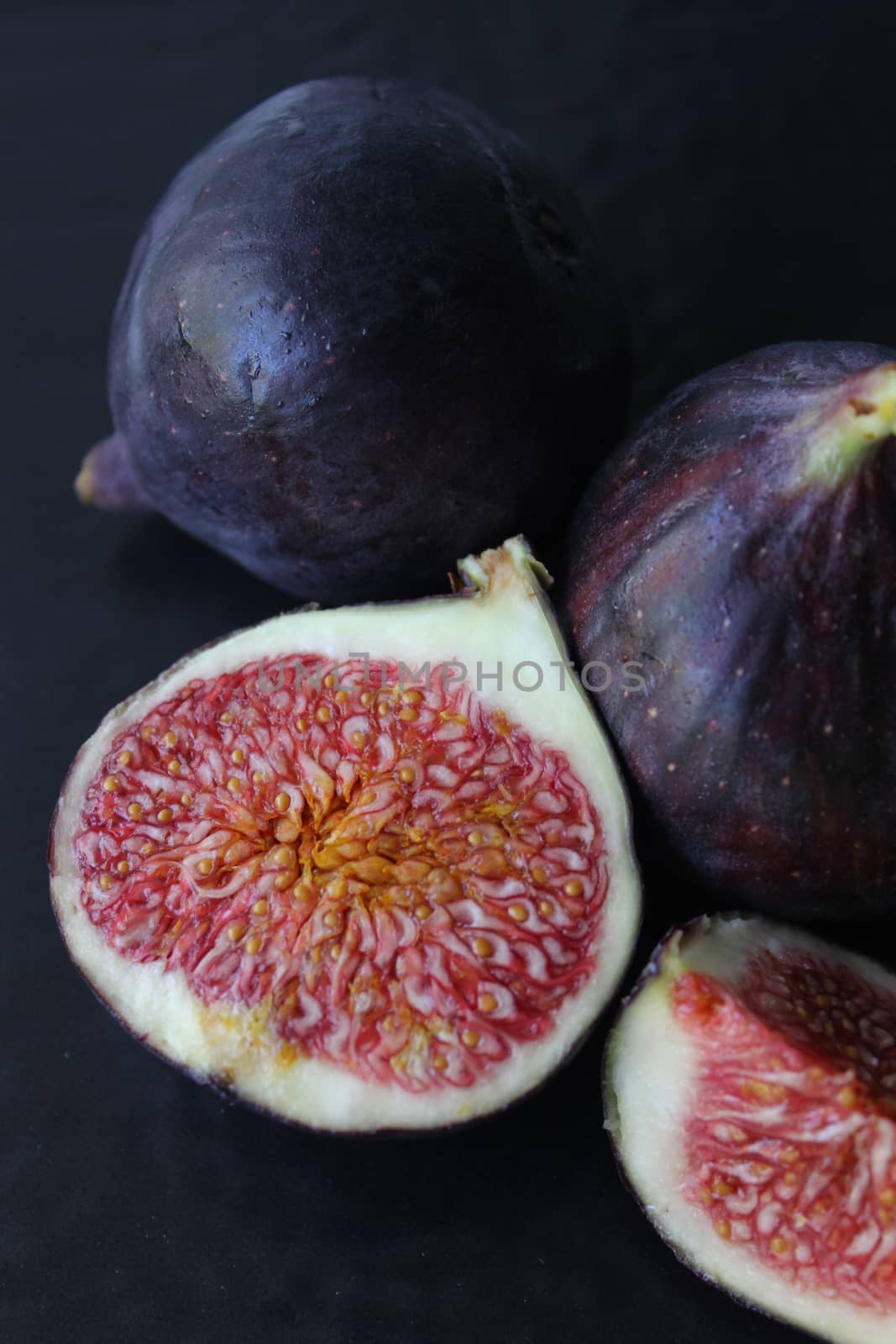Purple Fig slices on a dark background close-up.Texture or background