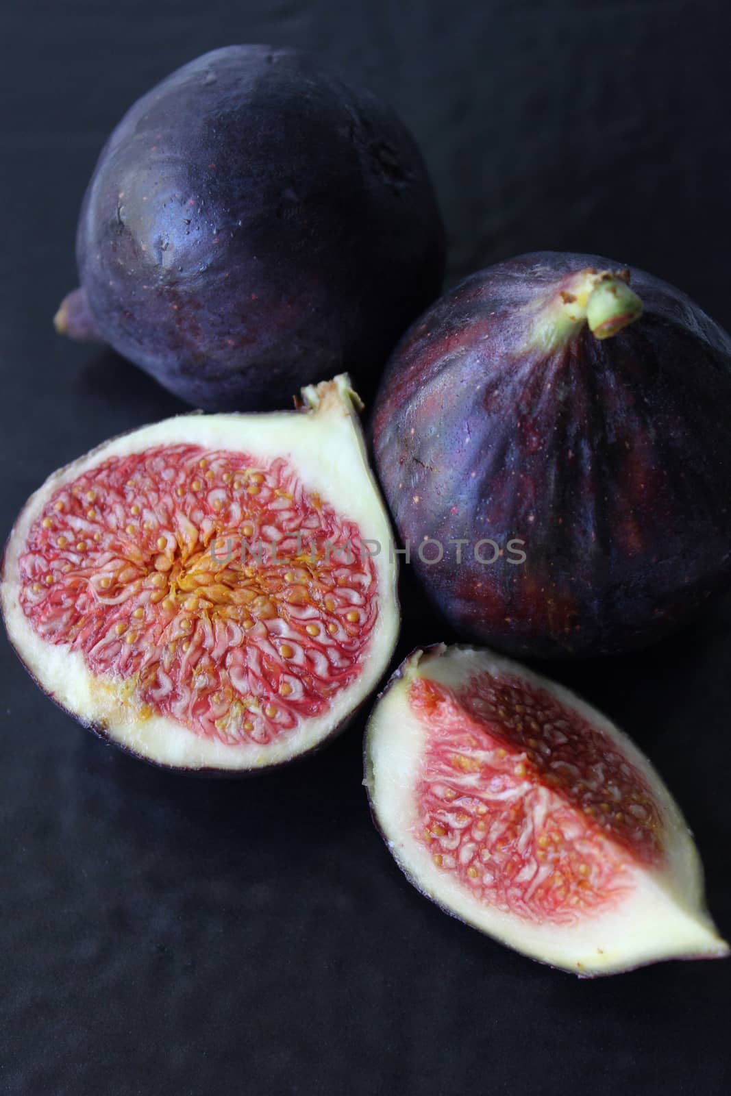 Juicy Fig slices on a dark background.Texture or background
