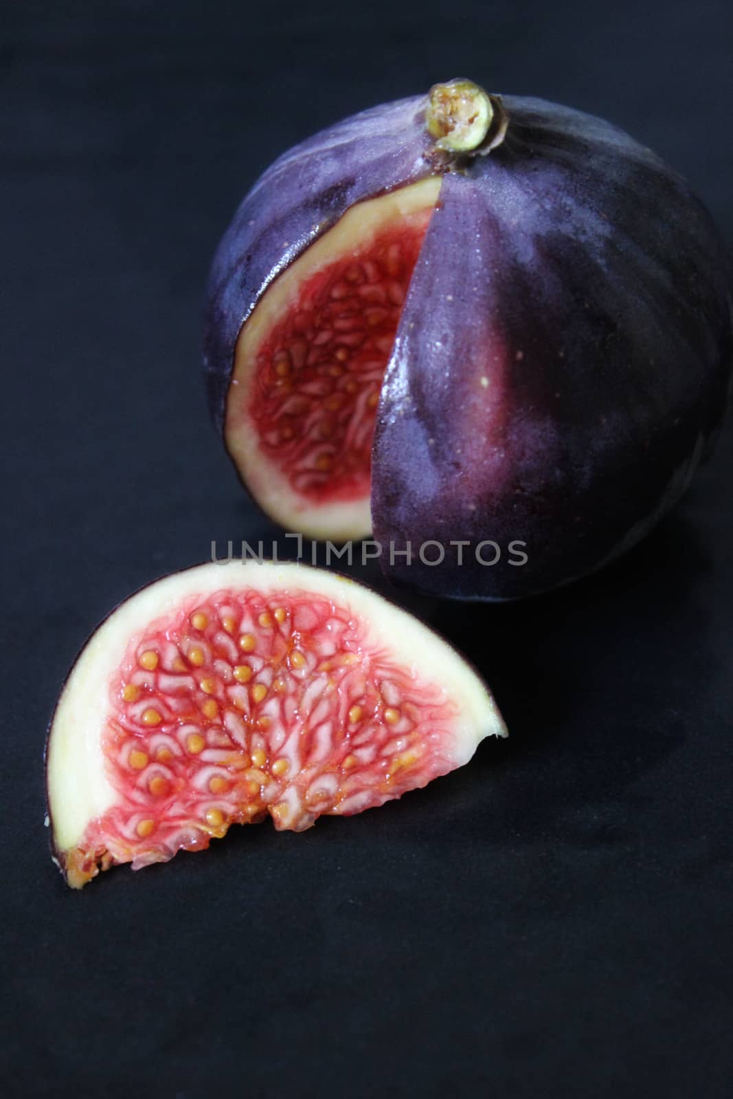 A slice of purple figs on a dark background .Texture or background