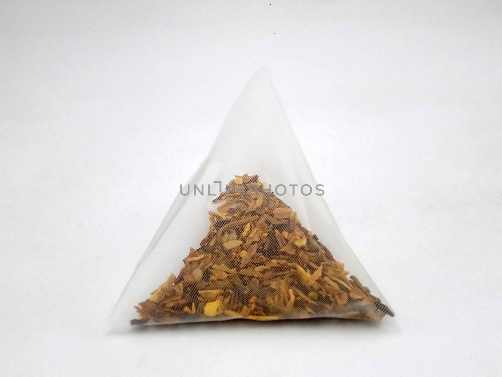 Orange and peach dried fruits cold infusion placed in mesh pyramid shape