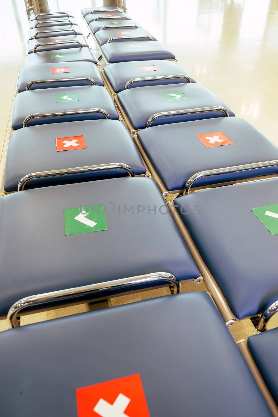 Social distancing, Rows of empty chairs in an airport's departure area marked with symbols regarding social distancing protocol to prevent the spreading of novel corona virus, COVID-19 in Thailand