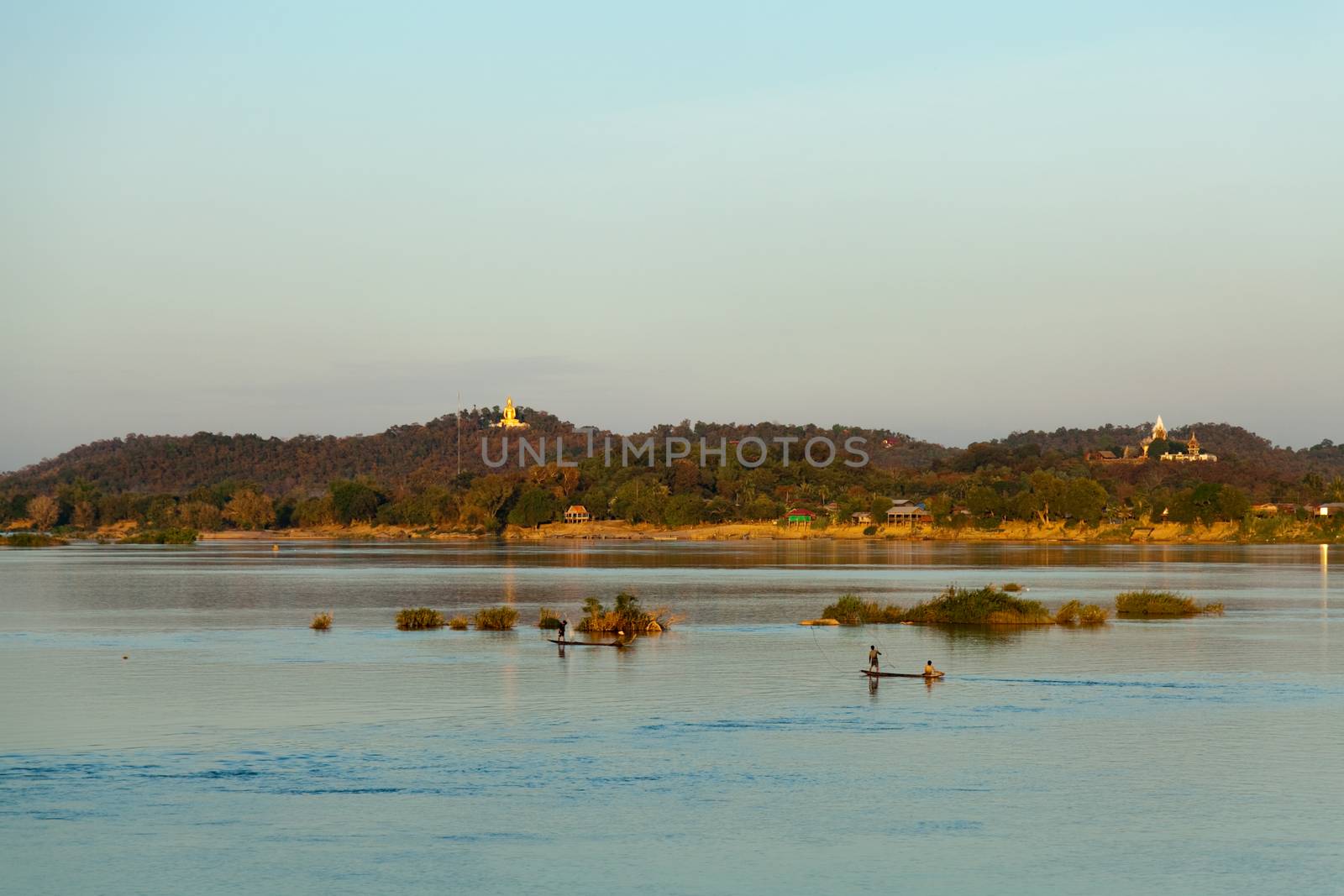 Muong Khong Laos 1/12/2012 Mekong river at sunset in blue hour and traditional fishing boats with nets golden Buddha in the distance . High quality photo