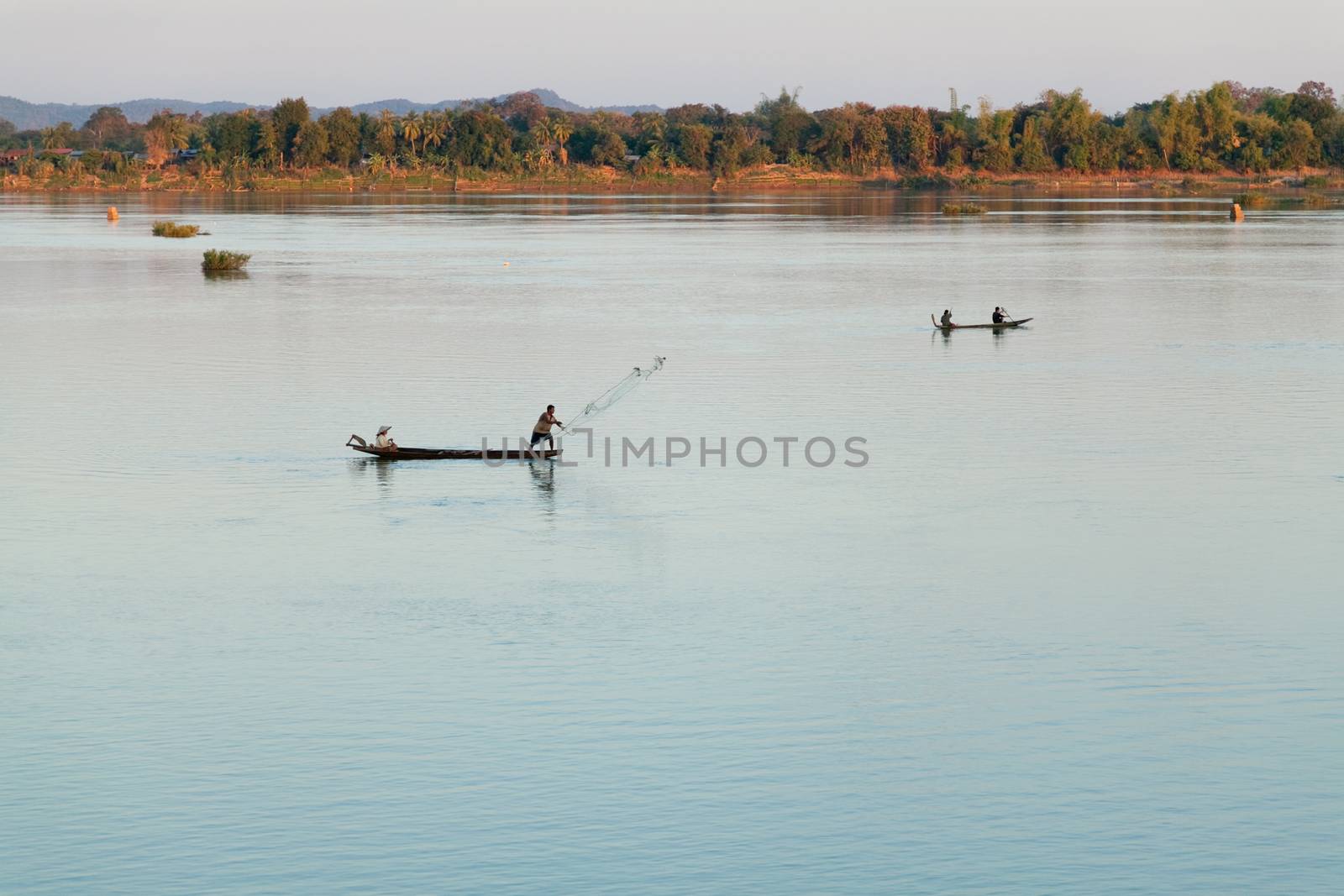 Muong Khong Laos 1/12/2012 Mekong river at sunset with and fishing boat and nets by kgboxford