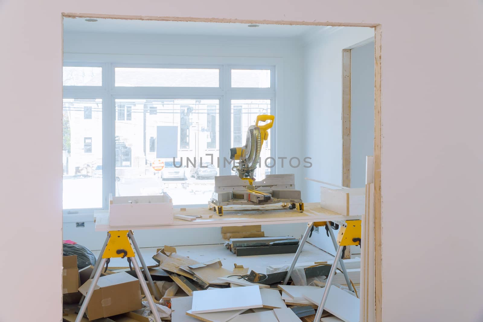 Construction remodeling home cutting wooden trim molding on with circular saw, saws a man