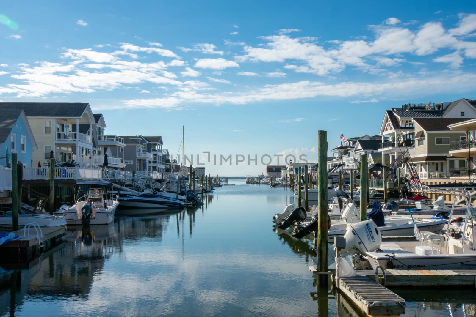 A View of a Canal With Boats and Houses on Each Side on a Clear  by bju12290