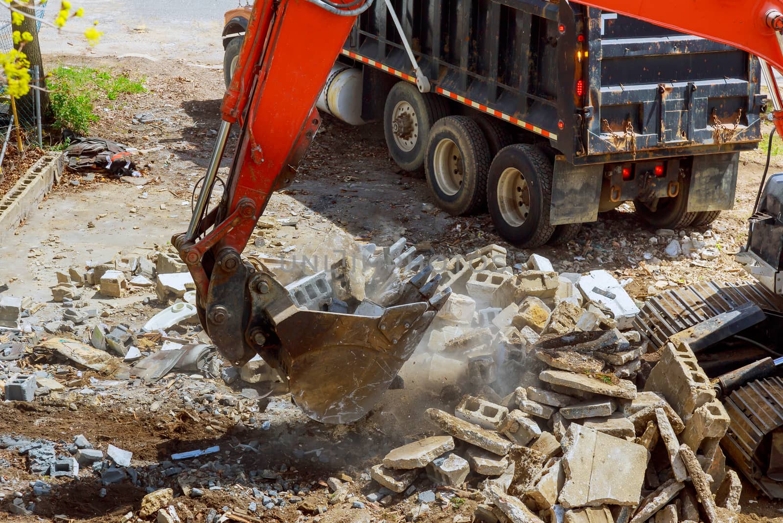 Excavator loads construction waste into of material for disposal from construction a home renovation or maintenance
