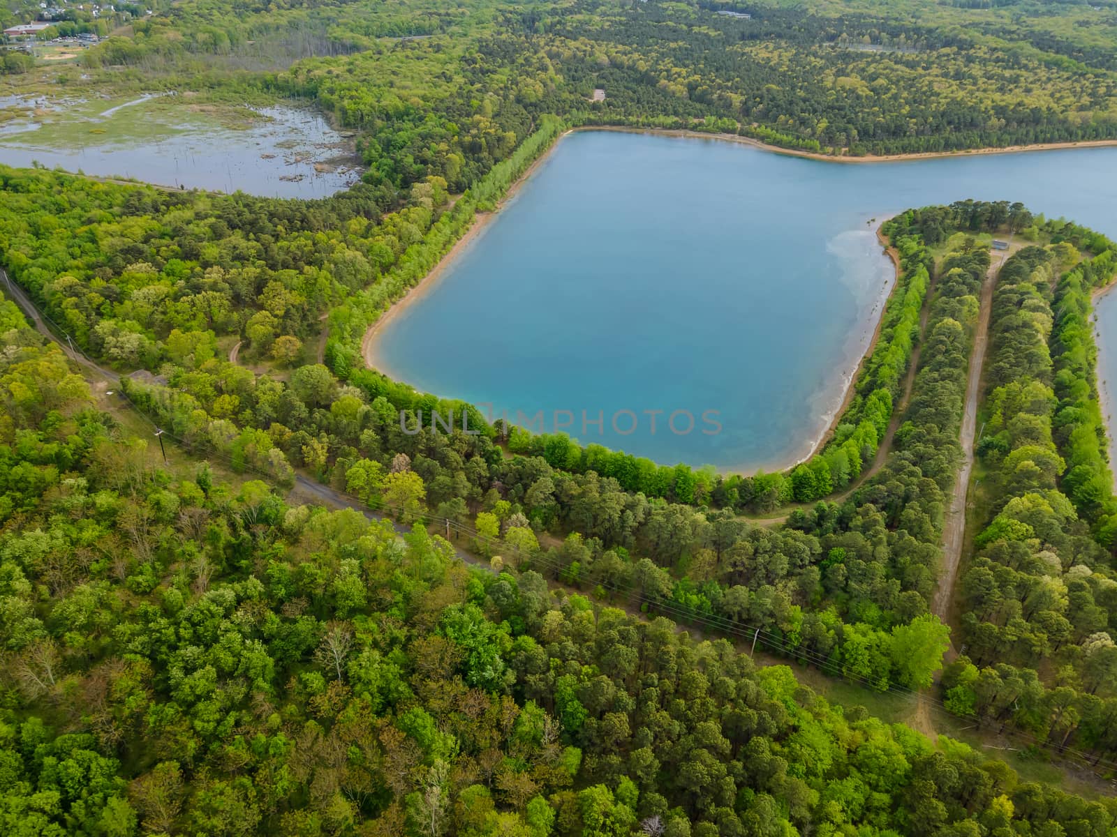 Aerial view panorama of idyllic natural pond of over trees forest