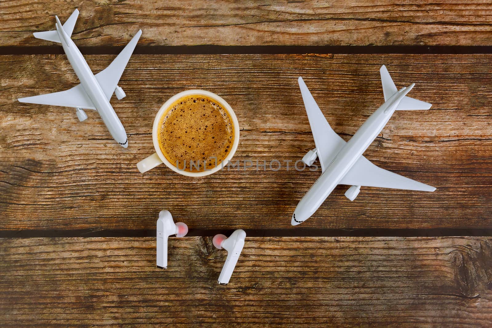 Summer holiday traveling concept planning model plane airplane in coffee cup and headphones