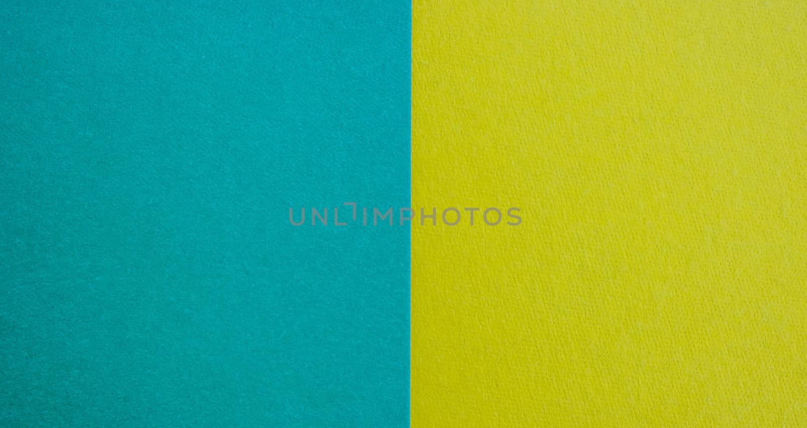 Blue-yellow background of matte suede, close-up. Velvety texture.