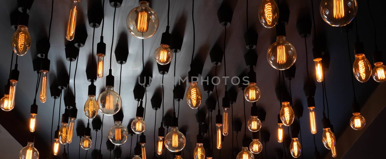Retro Edison lamp on a black background of the ceiling. Concept idea.