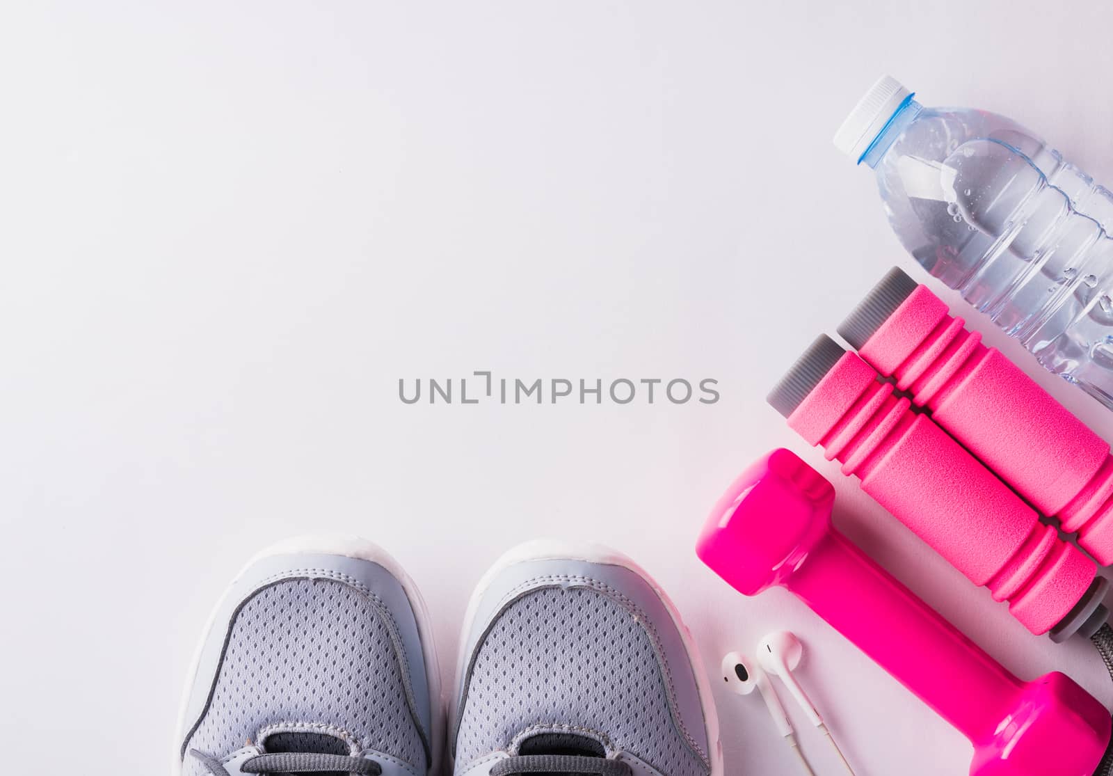 Pair sports shoes, headphones, dumbbell and water bottle on whit by Sorapop