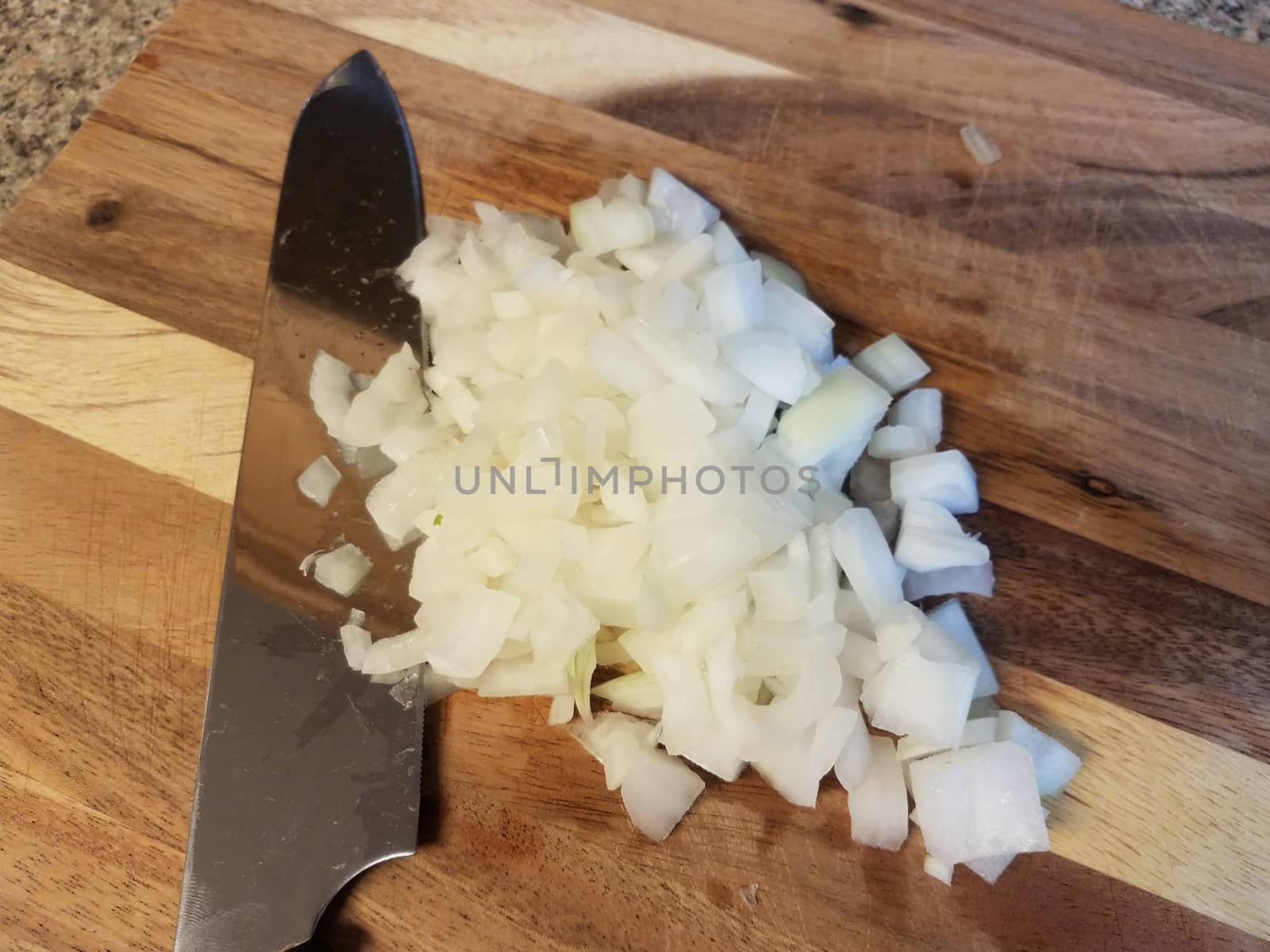 knife on wood cutting board with white onions by stockphotofan1