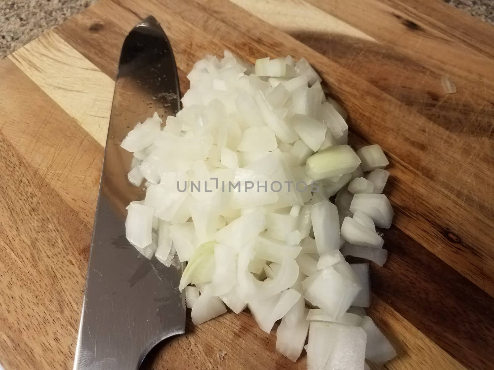 knife on wood cutting board with white onions by stockphotofan1