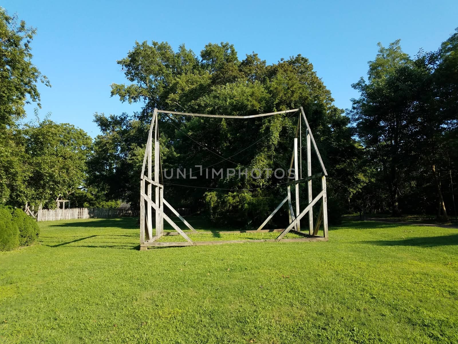 wood frame of old house with green grass or lawn and trees