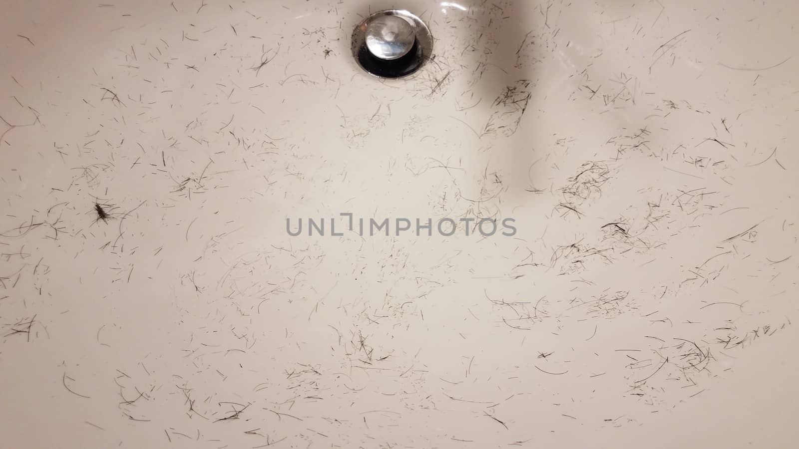 cut brown hair in white bathroom sink by stockphotofan1