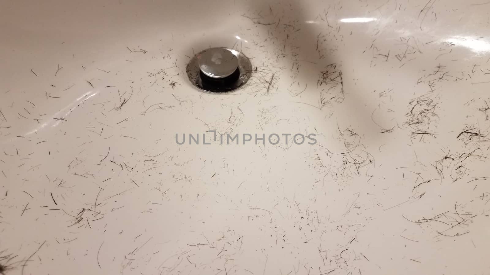 cut brown hair in white bathroom sink by stockphotofan1
