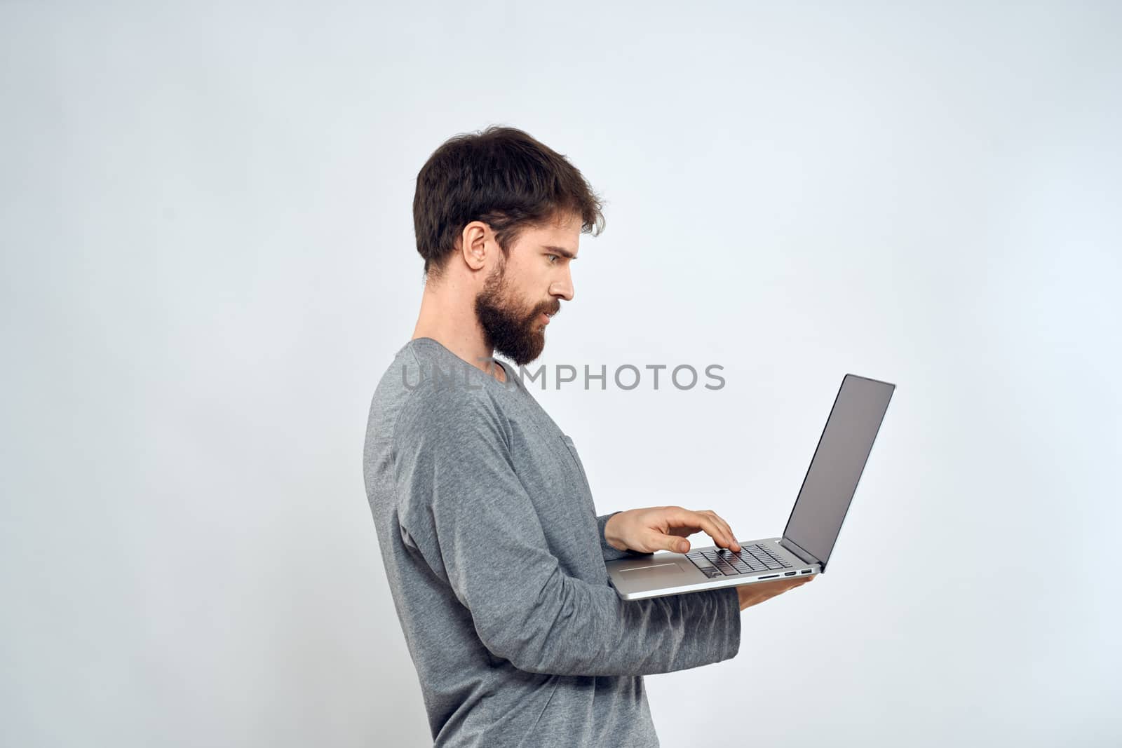 Bearded man with laptop in hands internet communication technology light background. High quality photo