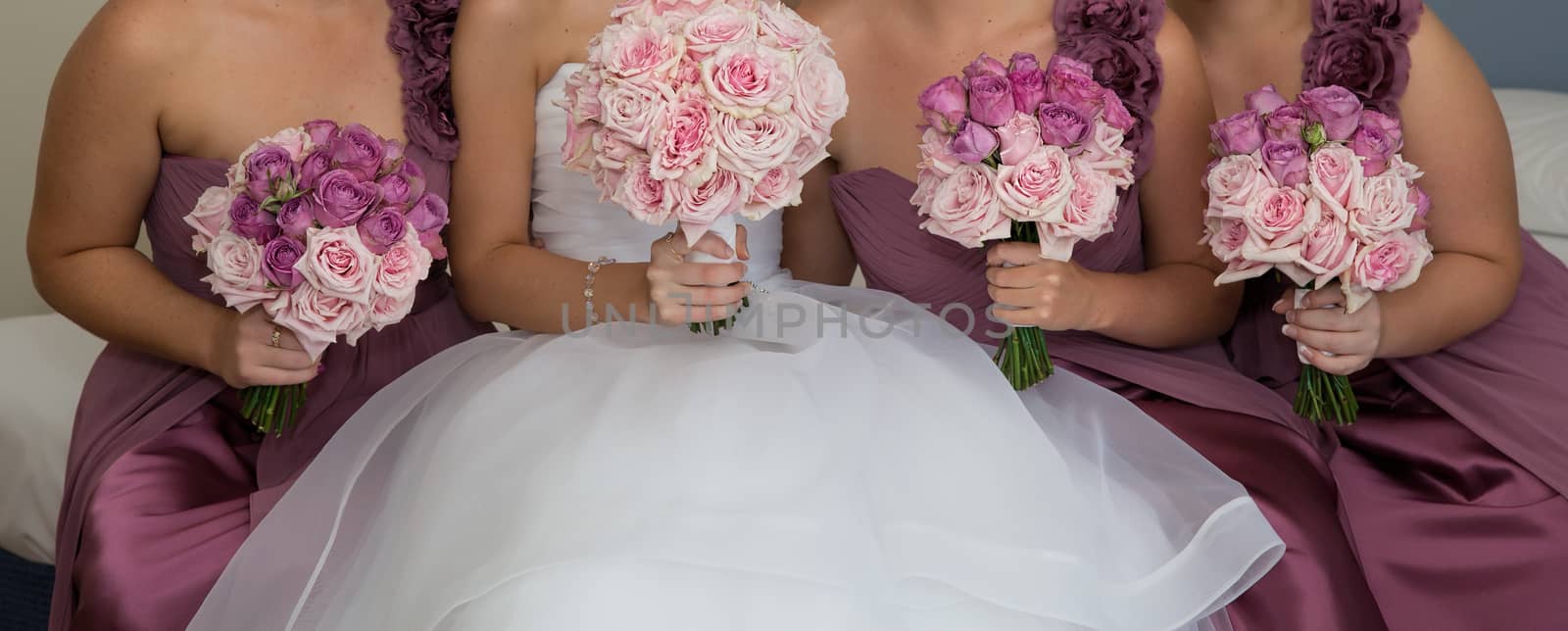 A bride with her bridesmaids all holding their bouquets and posing prior to the wedding ceremony