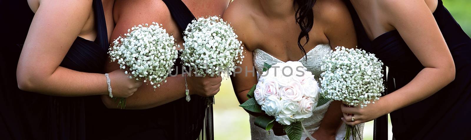 A bride with her bridesmaids all holding their bouquets and posing prior to the wedding ceremony