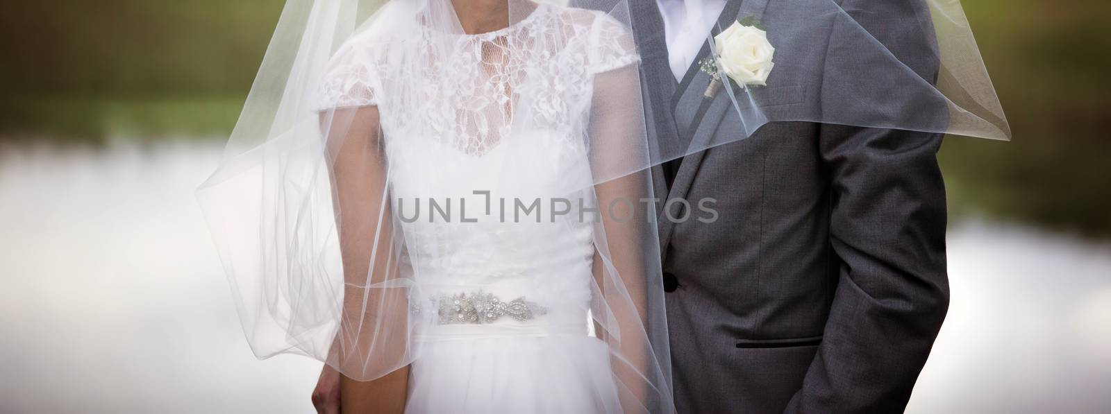 Newly married bride and groom pose with flowing veil