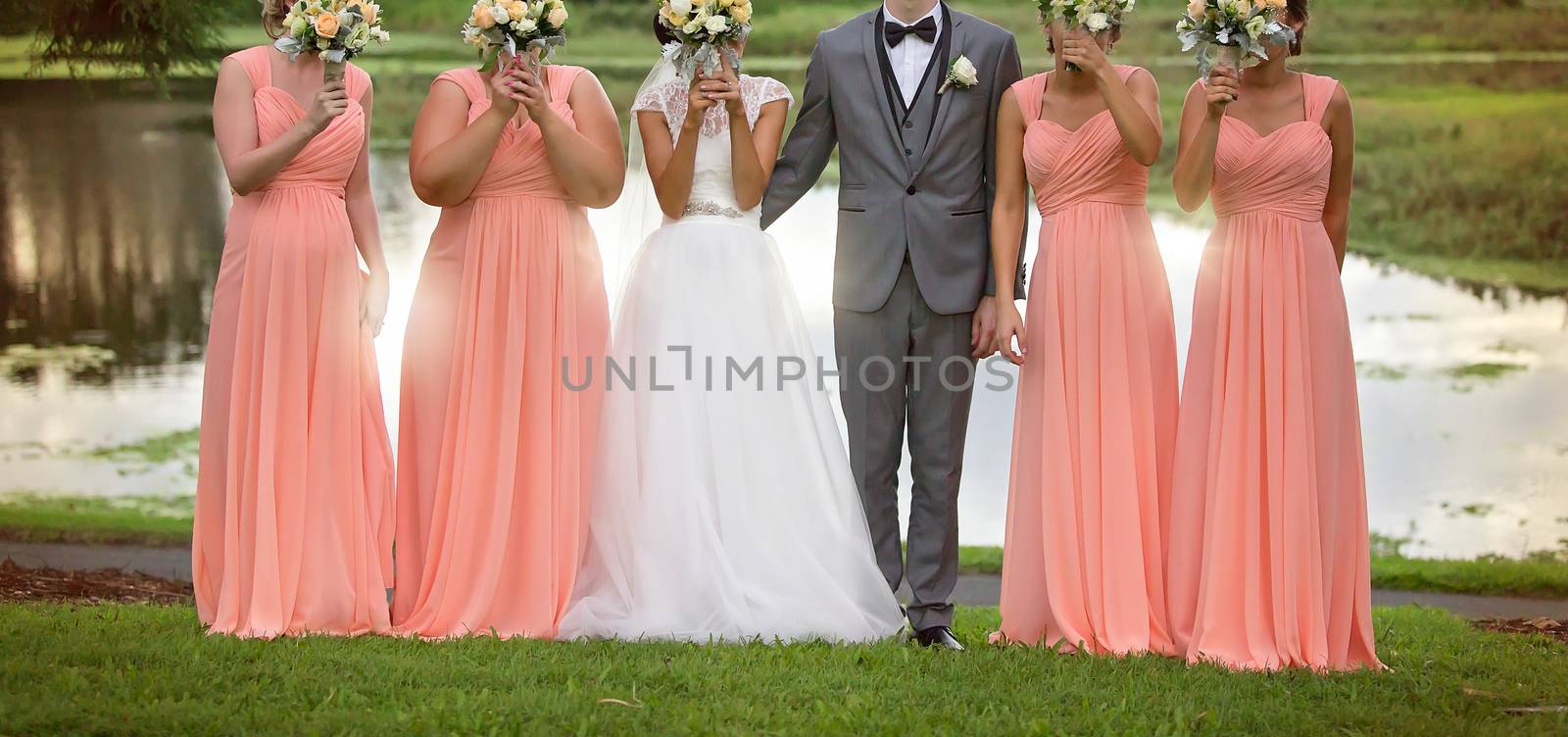 Bride, Bridesmaids and Groom in fun pose with bouquets after the wedding ceremony