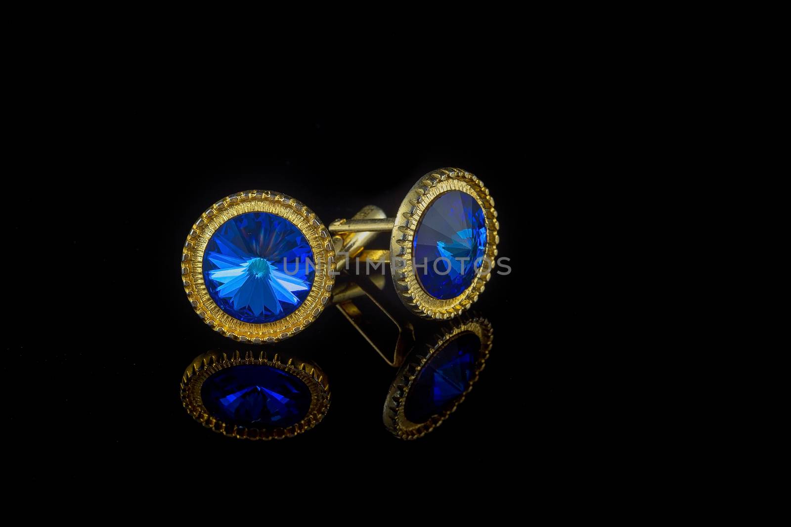 Vintage large gold blue stone cuff links on black background