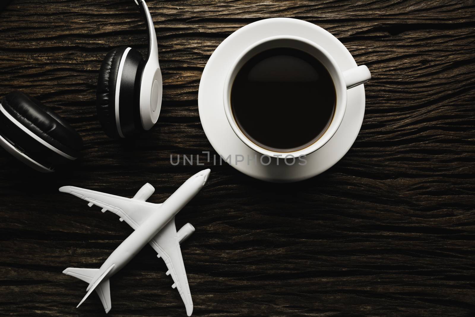 A cup of coffee with headphone on wooden table. Top view of coffee with copy space. Drink concept.