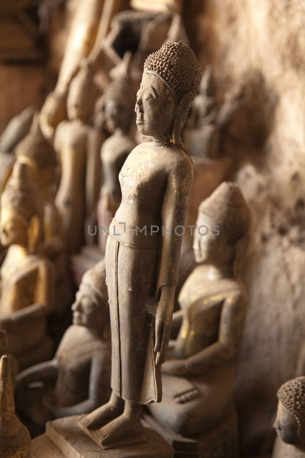 Ou Pak Caves Laos with small and miniature Buddha statues in many different pose by kgboxford