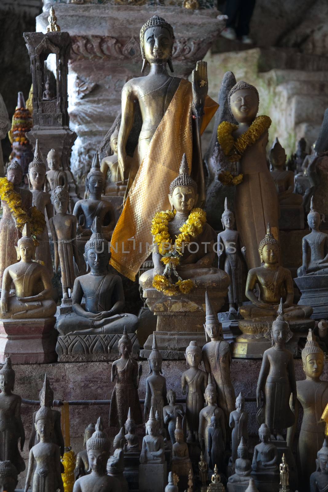 Ou Pak Caves Laos with small and miniature Buddha statues in many different pose by kgboxford