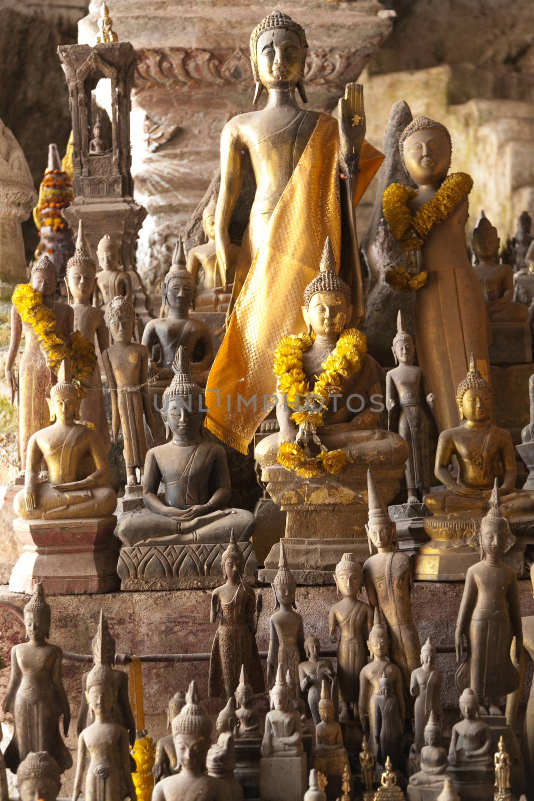 Ou Pak Caves Laos with small and miniature Buddha statues in many different pose by kgboxford