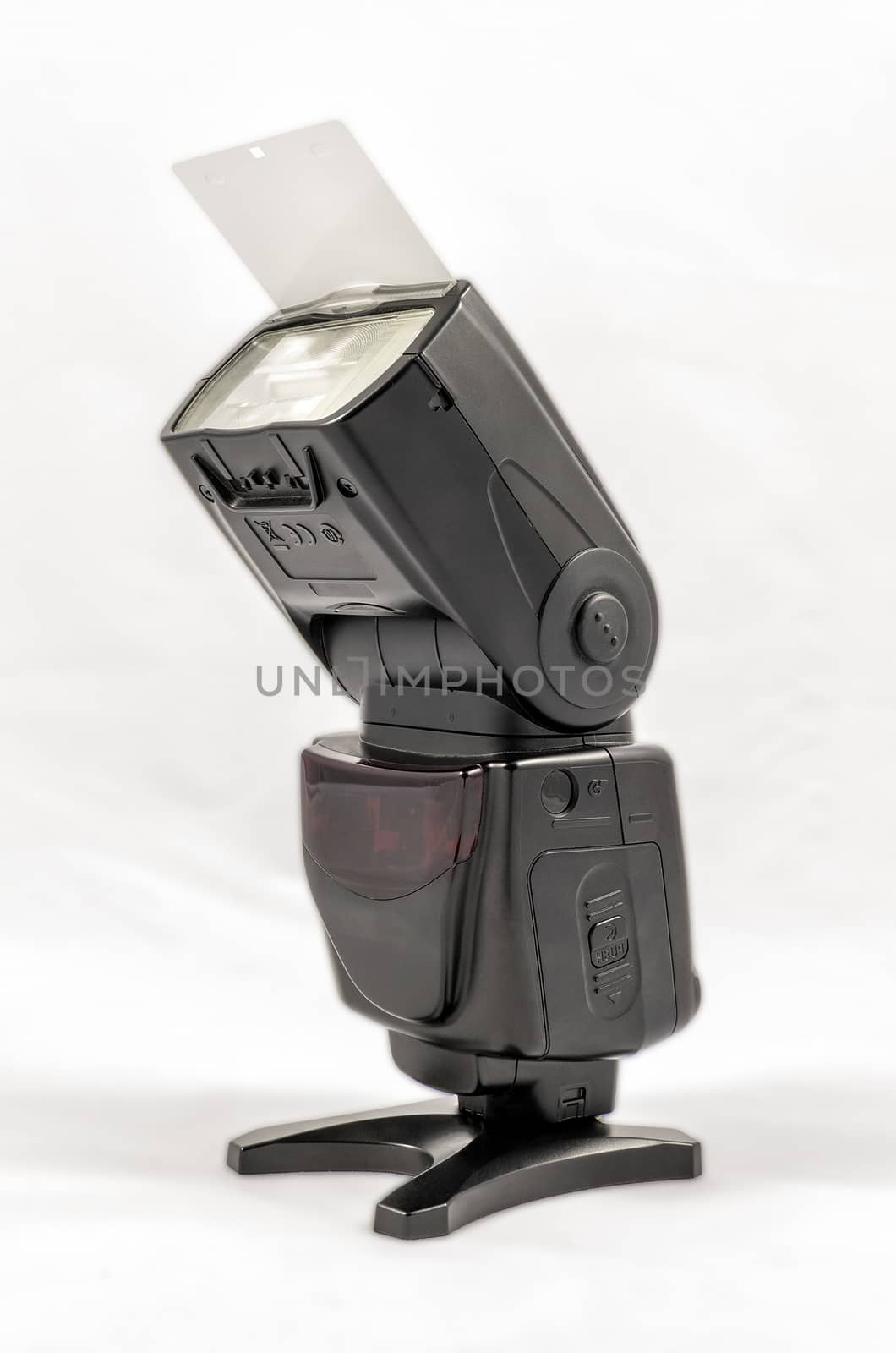 Oblique view of a black unbranded external flash unit for DSLR camera with bounce card extended