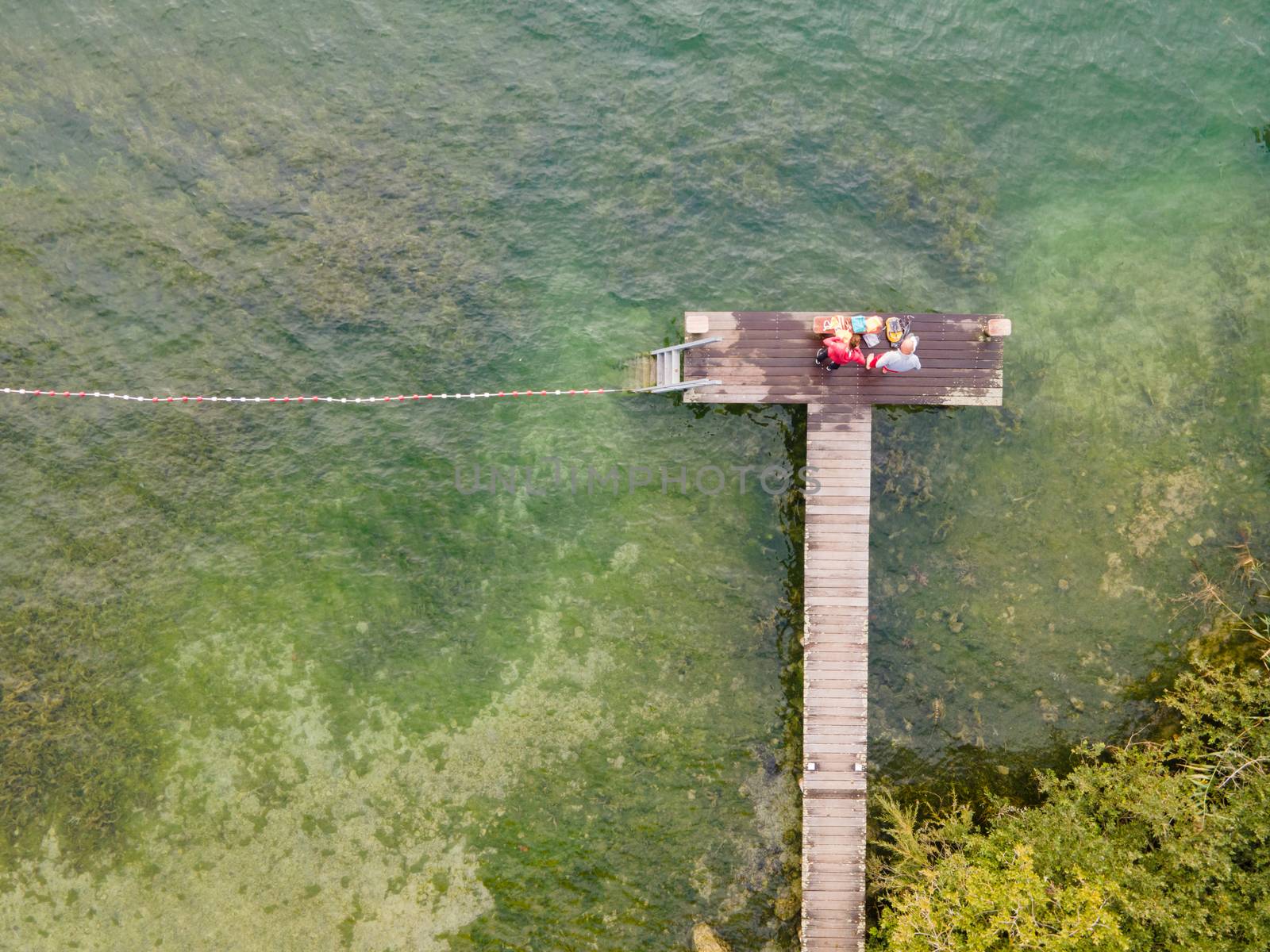 drone shot of people swimming in lake.