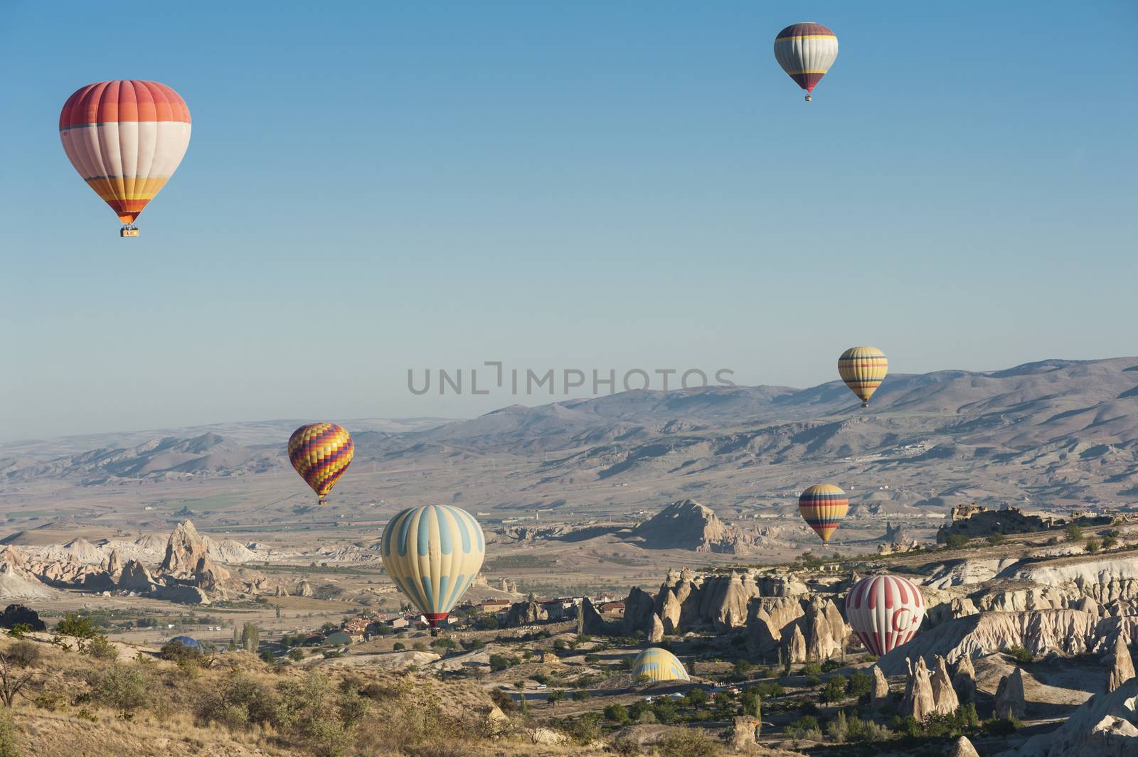 Hot air balloons flying over Cappadocia near Goreme at sunrise, Turkey