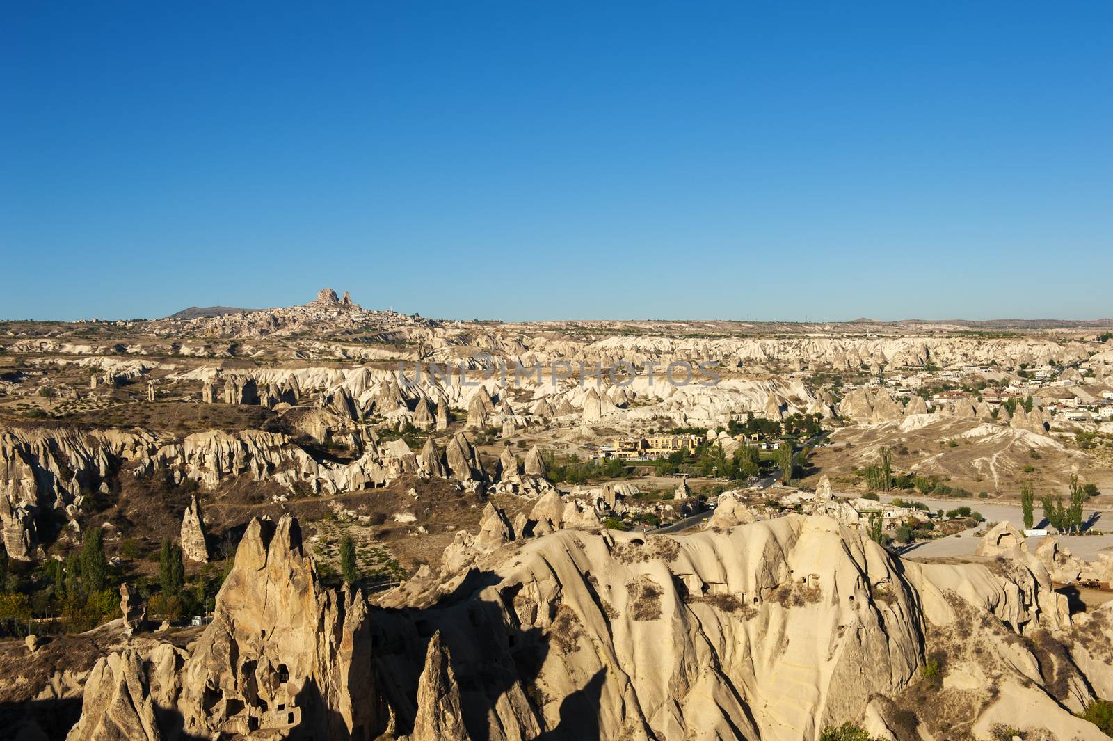 Ancient town and a castle of Uchisar dug from a mountains after sunrise, Cappadocia, Turkey