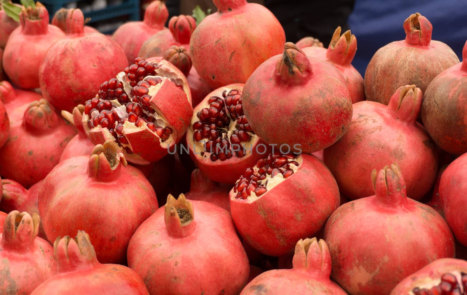 Ripe red pomegranates on the market. Cut pomegranates