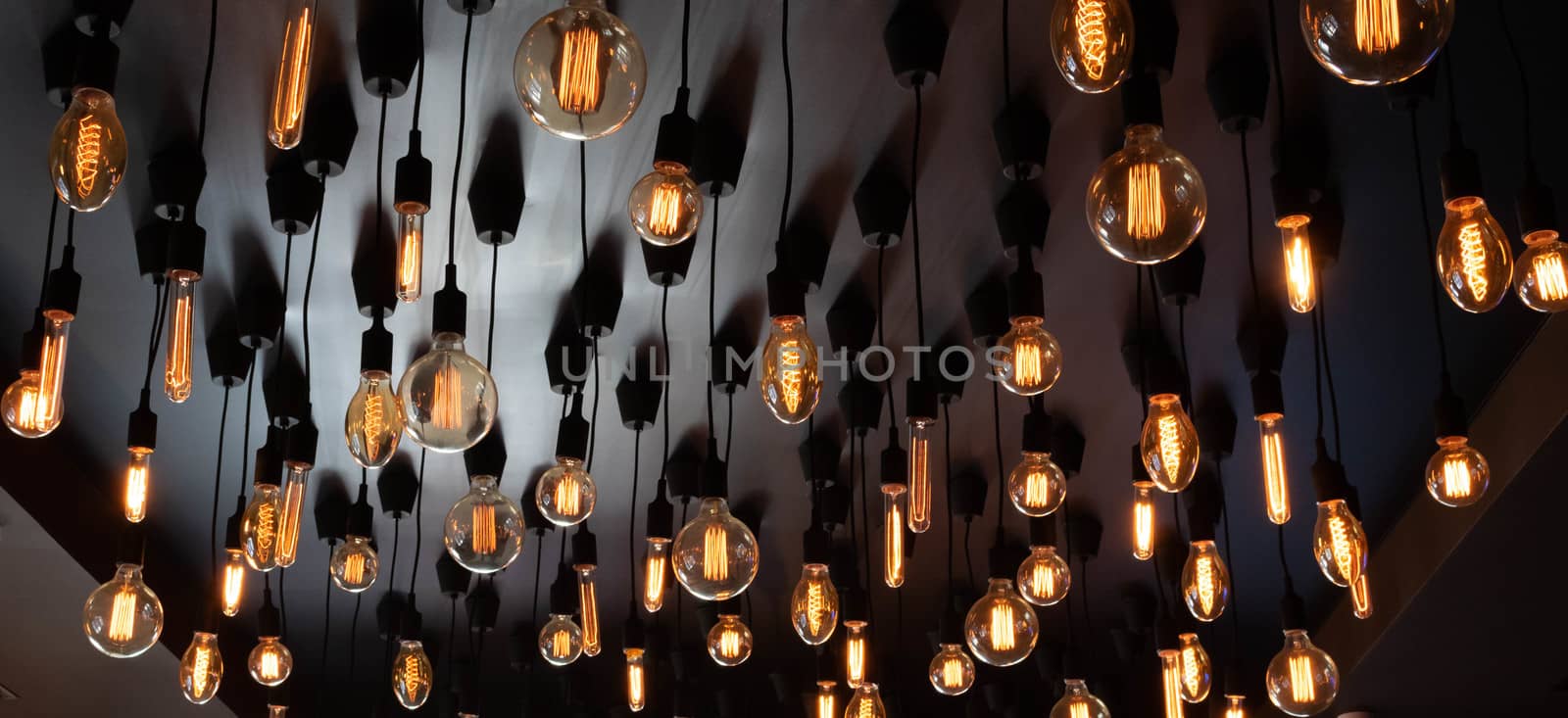 Retro Edison lamp on a black background of the ceiling. Concept idea.