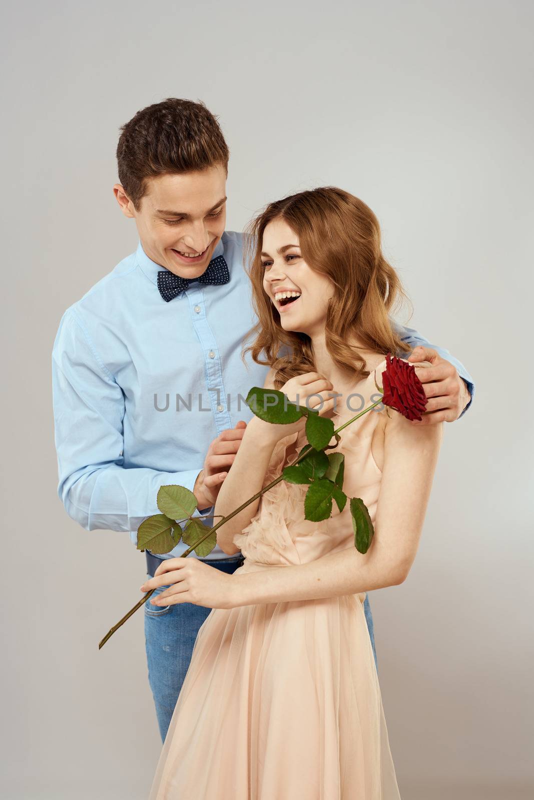 Young couple hugs romance dating lifestyle relationship light background red rose. High quality photo