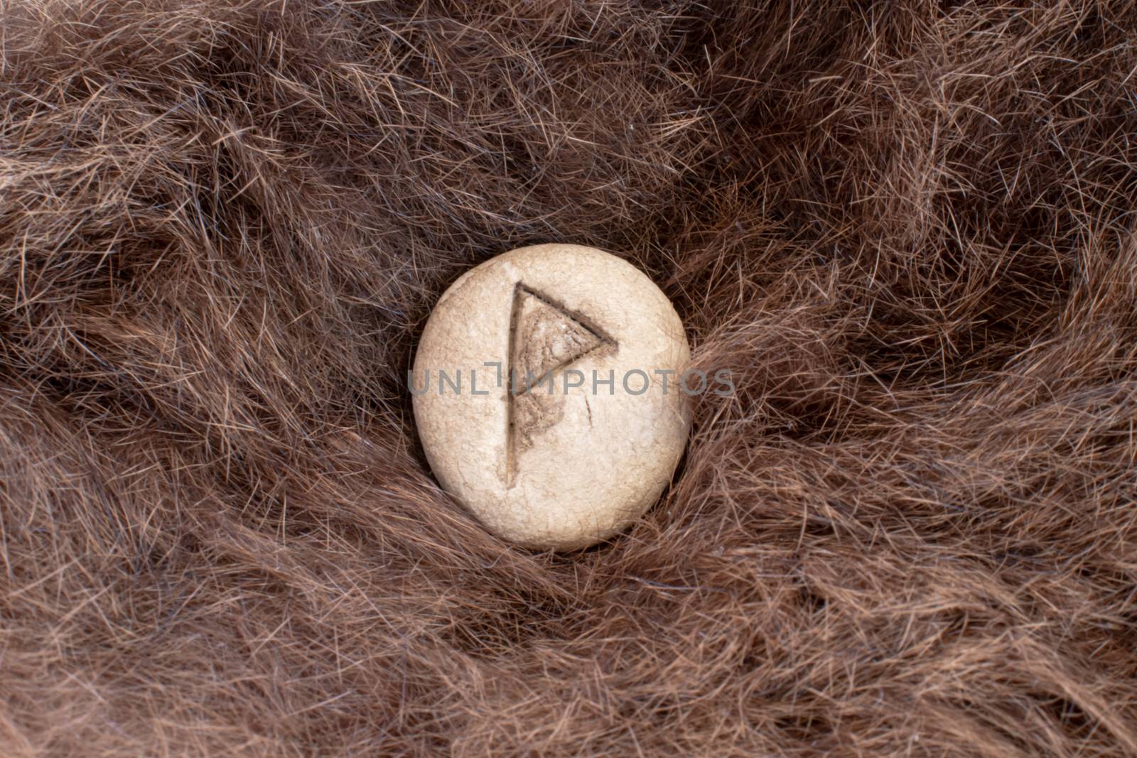 Wunjo Nordic stone rune on fur. Letter Wyn of the Viking alphabet.