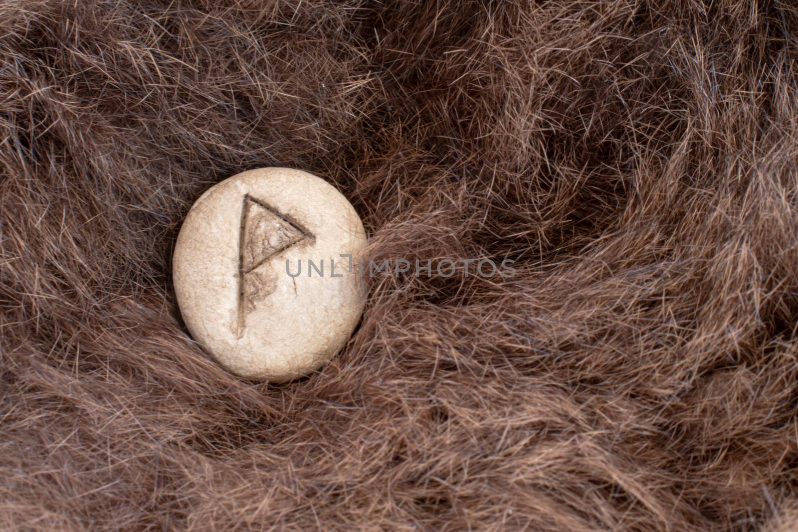 Wunjo Nordic stone rune on fur. Letter Wyn of the Viking alphabet.