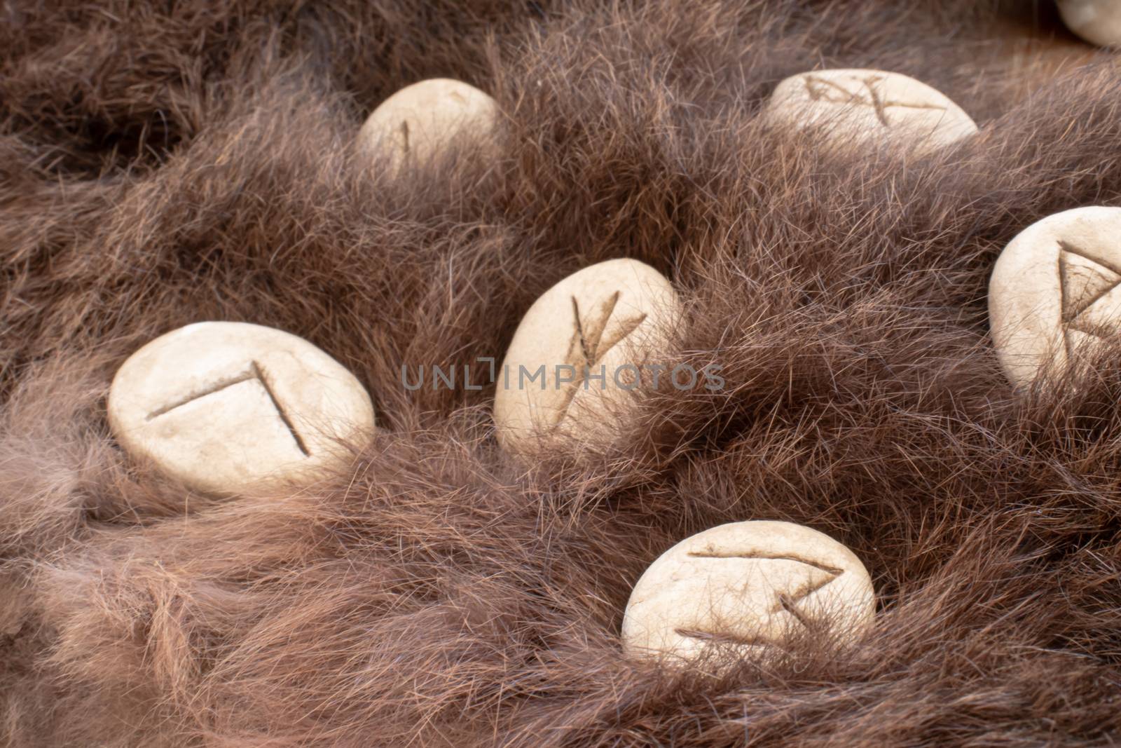 Stone runes on a fur. Futhark viking alphabet. Close up photo of Norse runes.