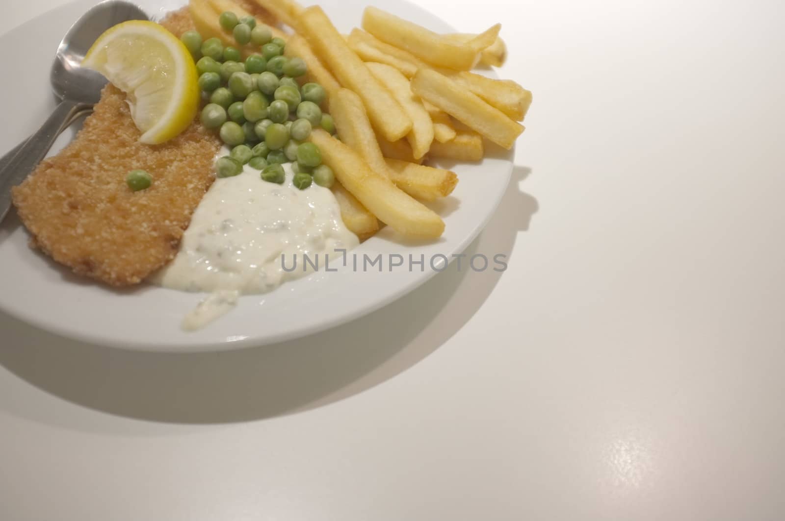 Fish and chips on a dish .