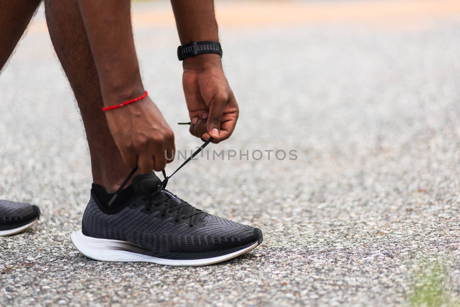 runner black man standing he trying shoelace running shoes by Sorapop