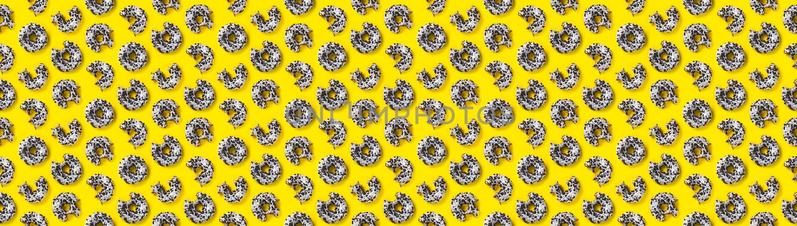 donuts on a yellow banner background top view. Flat lay of delicious nibbled chocolate donuts. used as donut banner or poster background, not pattern