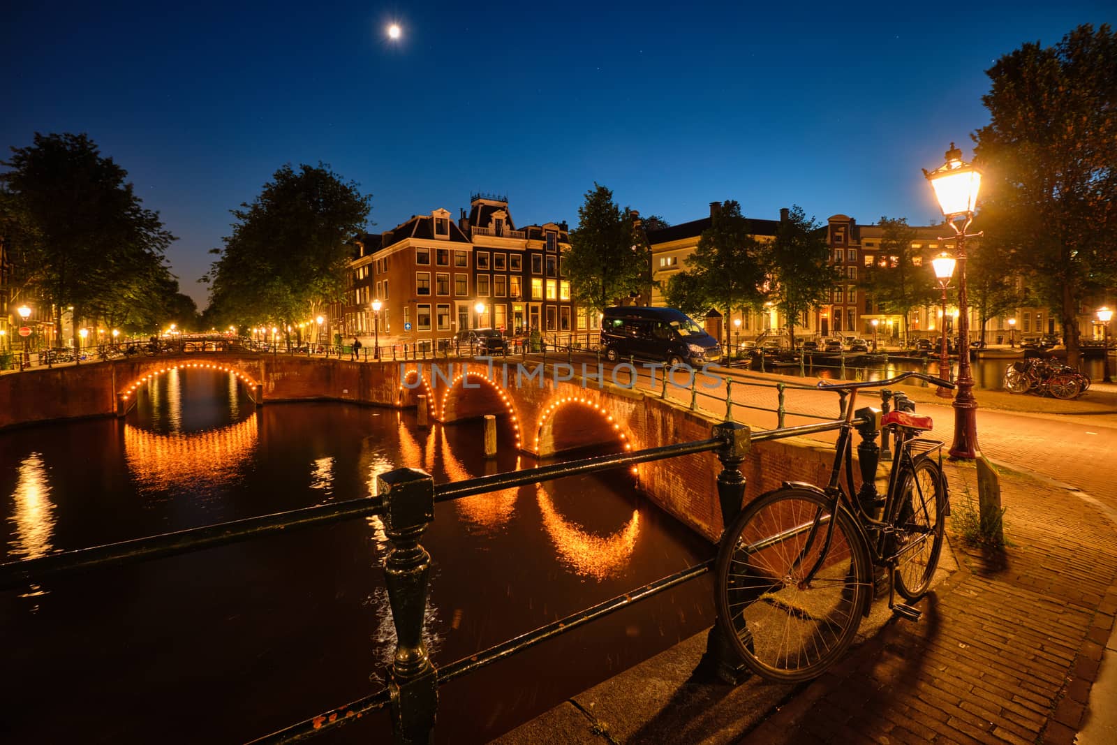 Amterdam canal, bridge and medieval houses in the evening by dimol