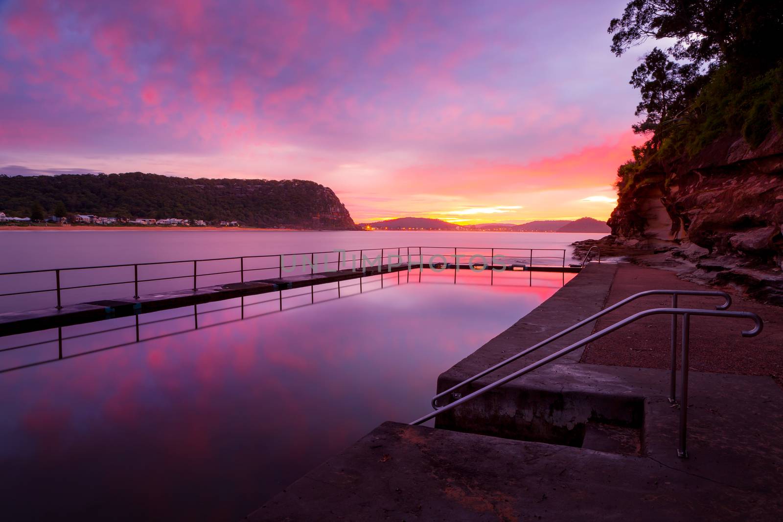 Red and pink dawn skies and beautiful reflections in the still waters of the rock pool