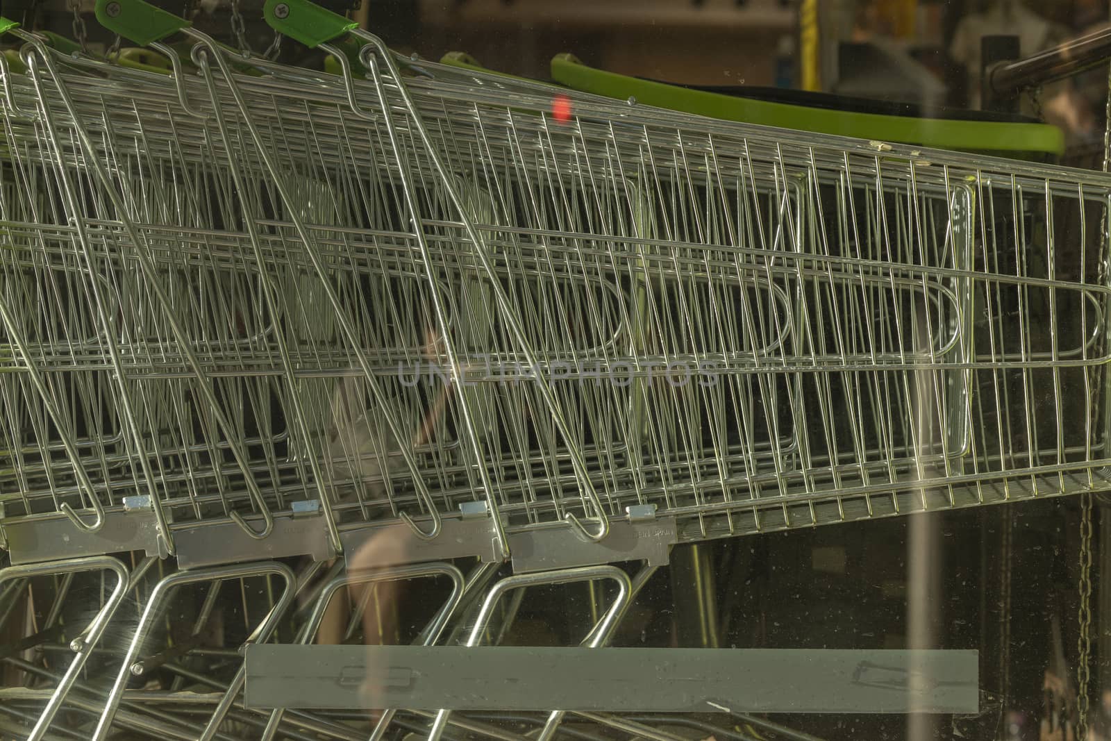 A group of metal shopping trolleys, made in Spain, stacked in the access area to a supermarket in Madrid, Spain.