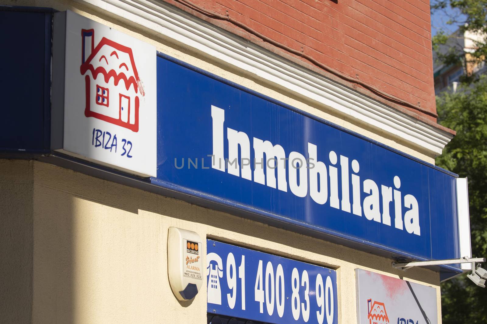 Madrid, Spain - May 18, 2020: Facade of the entrance area to an office open to the public for real estate services, buying and selling homes, in the Retiro district.