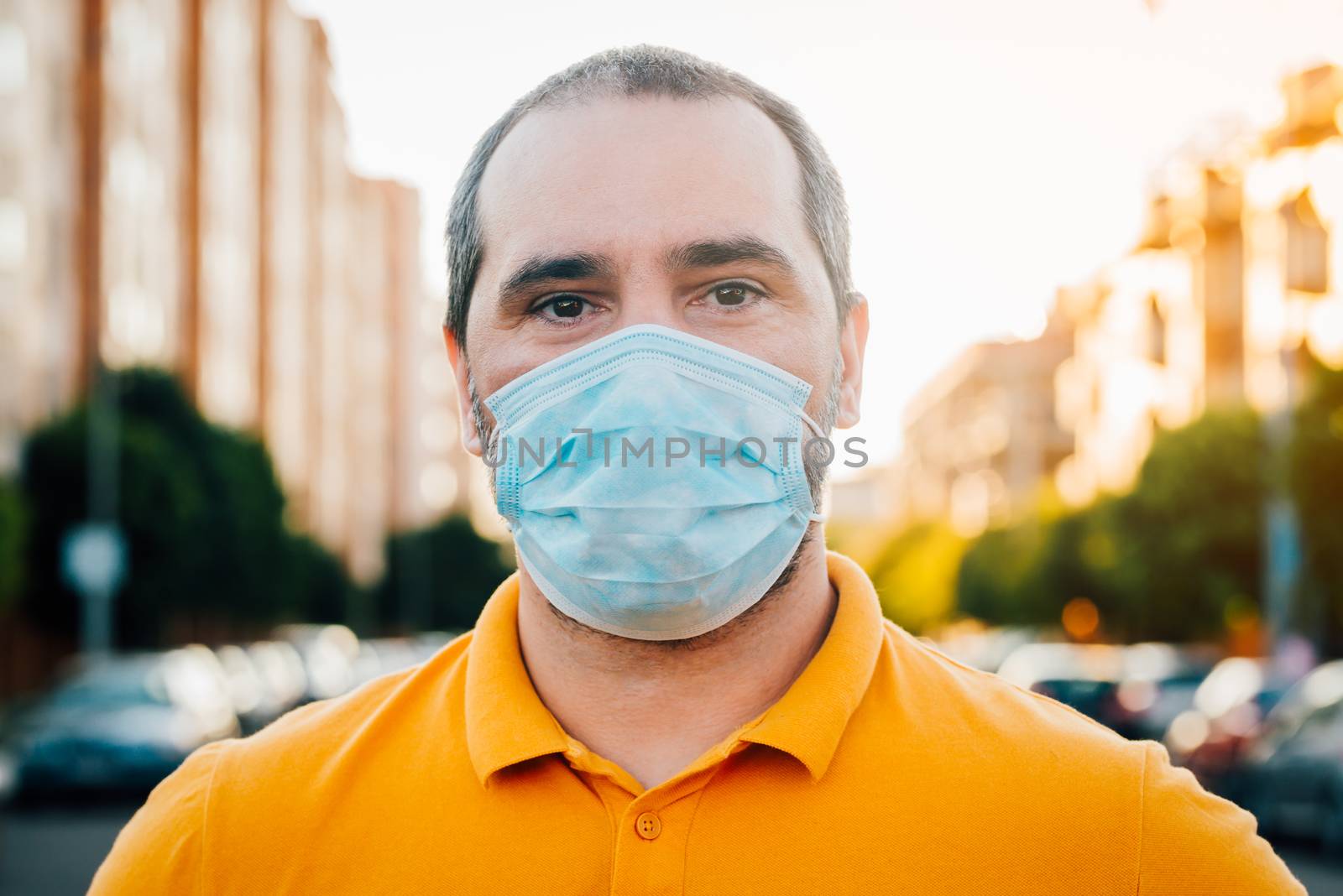 Close up portrait of 40s man in a disposable facial mask. by Fotoeventis