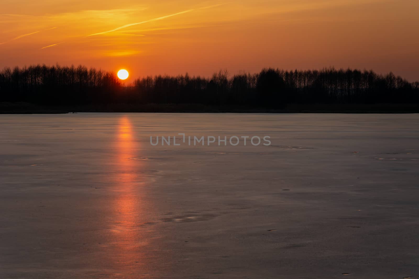 An orange sunset over a frozen lake, winter view, Stankow, Poland