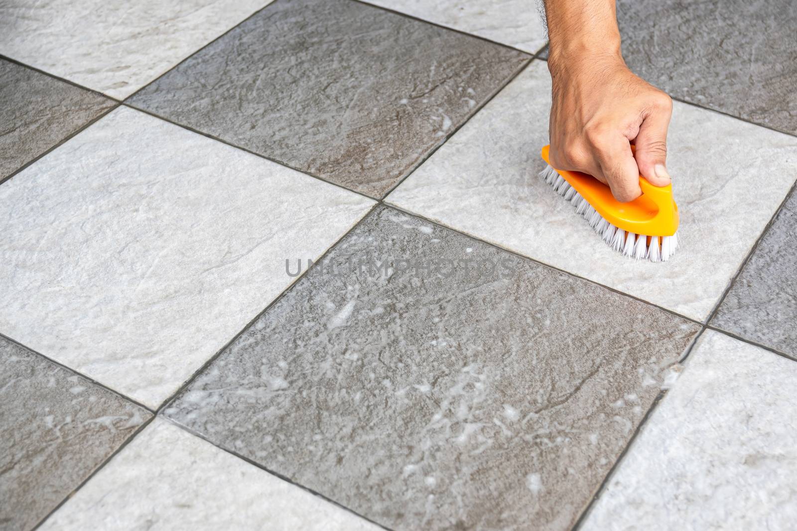 Men's hands are used to convert polishing cleaning on the tile floor.